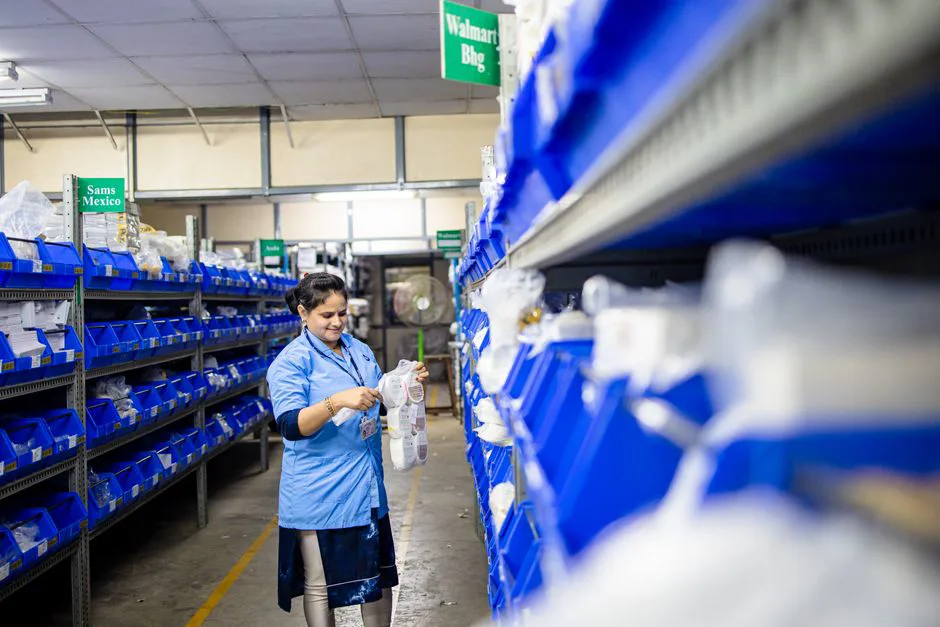 Warehouse interior with stacked boxes and a worker scanning a barcode in Mexico fulfillment center